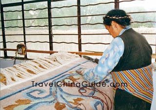 A Tibetan woman is weaving carpet.